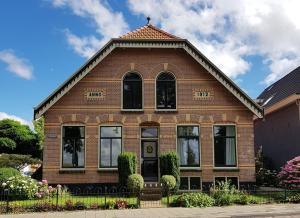 een rood bakstenen huis met zwarte ramen op een straat bij De Stadshoeve in Medemblik