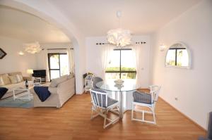a living room with a table and chairs at T3 Holiday Cottage near the beach | B111 in Porches +10 photos