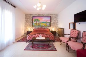 ein Wohnzimmer mit einem Bett und 2 Stühlen in der Unterkunft Villa Matohanca in Rovinj