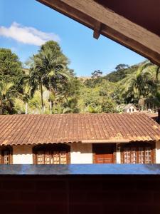a house with a tile roof and palm trees at Pesque pague pousada do Carlinho in Pinheiral