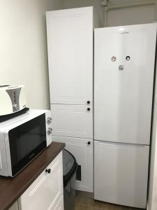 a kitchen with a microwave and a refrigerator at Comfy apartment in Carei