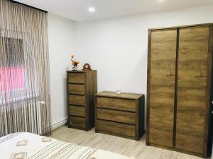 - une chambre avec des portes en bois, un lit et une table dans l'établissement Comfy apartment, à Carei