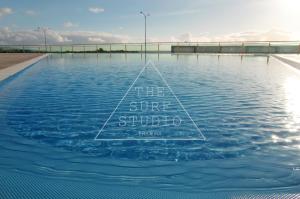 a swimming pool with a sign that reads the surf studio at The Surf Studio - Ericeira in Ericeira