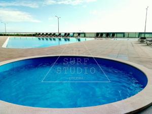 a swimming pool with blue water in a building at The Surf Studio - Ericeira in Ericeira