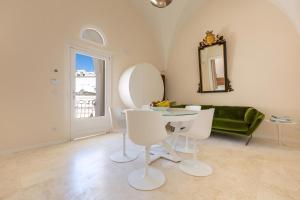 ein Wohnzimmer mit einem Tisch und einem grünen Sofa in der Unterkunft Palazzo Mascetti Executive Rooms in Ostuni