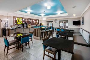 a restaurant with tables and chairs and a bar at La Quinta by Wyndham Conroe in Conroe