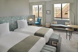 a hotel room with two beds and a living room at Mövenpick Hotel The Hague in The Hague