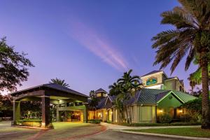 a house with a palm tree in front of it at La Quinta by Wyndham Ft. Lauderdale Plantation in Plantation