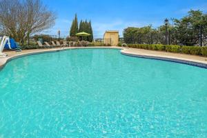 a large pool with blue water in a yard at La Quinta by Wyndham Baton Rouge Siegen Lane in Baton Rouge