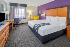 a hotel room with a large bed and a desk at La Quinta by Wyndham Baton Rouge Siegen Lane in Baton Rouge