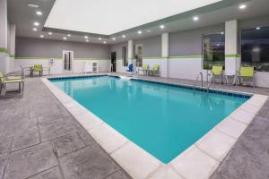 een groot zwembad met blauw water in een hotelkamer bij La Quinta by Wyndham College Station South in College Station
