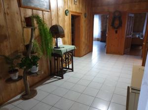 a hallway with a table and plants in a room at Kerka-Völgyi Vendégház in Kerkaszentkirály
