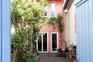 an entrance to a pink house with a table and chairs at Klimatisiertes Loft im Herzen von Deidesheim in Deidesheim