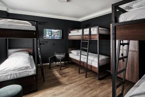 a room with three bunk beds and a chair at GRONERS Leipzig City Center in Leipzig