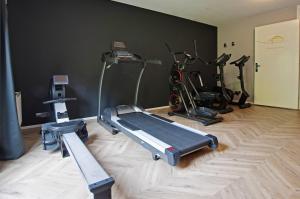 een fitnessruimte met diverse hometrainers in een kamer bij Boetiek Hotel BonAparte Lochem in Barchem