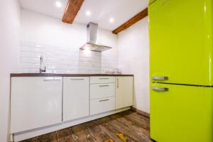cocina con armarios blancos y nevera verde en Blacksmith Old Town Apartments en Tallin