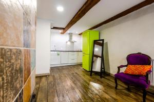 Habitación con silla morada y armario verde. en Blacksmith Old Town Apartments en Tallin