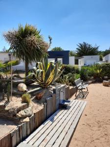 a garden with a bench and a chair on the beach at CLOS DE L'OCEAN 2 - maison 3 chambres à 300 m de la plage in Saint-Jean-de-Monts