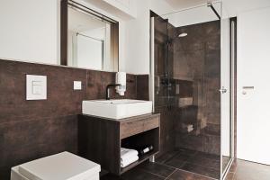 a bathroom with a sink and a shower and a toilet at GRONERS Leipzig City Center in Leipzig +37 photos