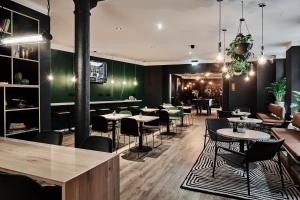 a restaurant with tables and chairs in a room at GRONERS Leipzig City Center in Leipzig