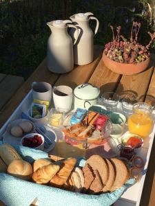 ein Tablett mit Brot und anderen Lebensmitteln auf dem Tisch in der Unterkunft B&B HemeltjeLief in Hemelum