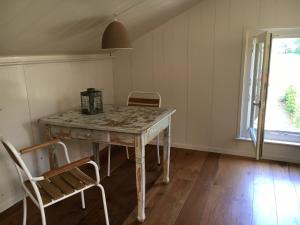 a table and chairs in a room with a window at B&B HemeltjeLief in Hemelum