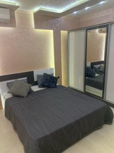 a bedroom with a large bed and a large mirror at Obzor Tatyana Apartaments Nemo in Obzor