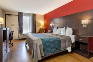 a hotel room with a bed and a television at Econo Lodge North in Charleston