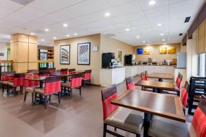 a restaurant with wooden tables and red chairs at Comfort Inn & Suites Durham near Duke University in Durham