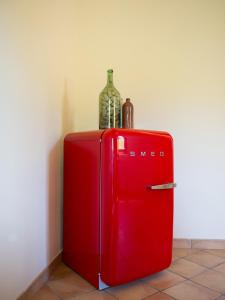 a red refrigerator with a bottle and a wine glass on top at Casa dell'Orto in San Vito Chietino