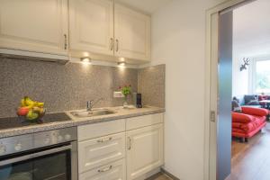 a kitchen with white cabinets and a sink at Oberstdorfer Bergwelt 108 in Oberstdorf