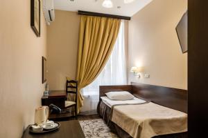 ein Hotelzimmer mit einem Bett und einem Fenster in der Unterkunft M-Hotel in Sankt Petersburg