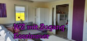 een woonkamer met een bank en een keuken bij Landhaus "Kühler Morgen", Komfortable 65 qm FeWo mit gehobener Ausstattung, Garten, baby- und kindgerecht in Saalburg