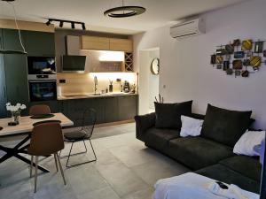 a living room with a couch and a table and a kitchen at Romana Dream apartment in Vrsar