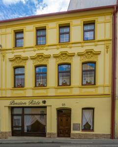 un bâtiment jaune avec les mots bureau de jardin sur lui dans l'établissement Penzion Růže, à Benešov nad Ploučnicí
