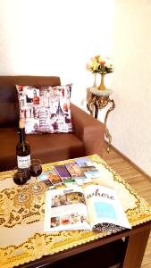 uma mesa de centro com um livro e uma garrafa de vinho em Fantaflat Old Tbilisi Apartment em Tbilisi