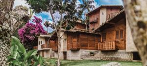 a house with wooden balconies on the side of it at Pousada Aracê in Pedra Azul