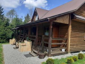 a log cabin with a porch and a door at Siedlisko Bieszczadzkie 1 in Lutowiska +2 photos