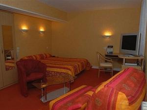 ein Hotelzimmer mit 2 Betten und einem Schreibtisch in der Unterkunft Logis Hotel Du Commerce in Pont-d'Ouilly
