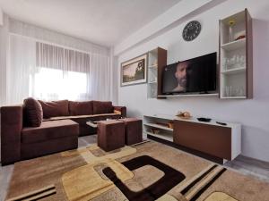 a living room with a couch and a tv at VIP Apartment-Brilliant Apartments in Constanţa