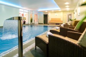 a hotel pool with chairs and a swimming pool at Hotel & Restaurant Villa Ulmenhof in Bredstedt