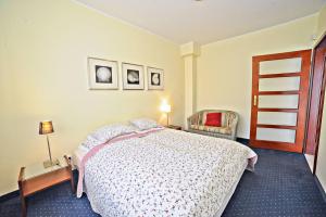 a bedroom with a bed and a chair at Grand Apartments - Parkur Apartment with terrace in Sopot