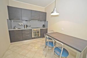 a kitchen with a wooden table and two chairs at Grand Apartments - Parkur Apartment with terrace in Sopot