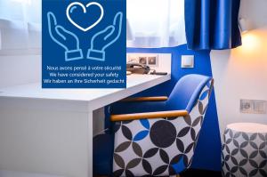 baño con encimera azul y blanco con silla azul y blanca en Hôtel ORIGAMI, en Estrasburgo