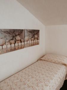 a bedroom with a bed and two pictures on the wall at La Casetta in Montagna in Pietracamela