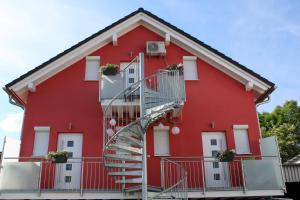uma casa vermelha com uma escada em espiral em Ferienwohnung Misita em Rust