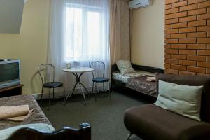 a living room with a couch and a tv and a table at Hotel-restaurant complex S Legkim Parom in Brovary
