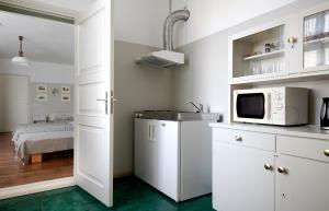 a kitchen with white cabinets and a microwave at Promenaadi Villa in Pärnu