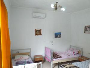 een slaapkamer met 2 aparte bedden en een kroonluchter bij Rozafa Ferry & Accommodation in Koman
