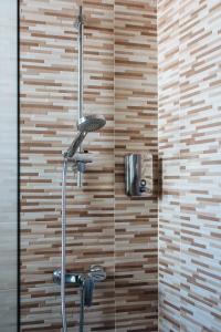 a shower in a bathroom with a wooden wall at Hostly Plaza de Armas Lightfull loft-Center-Parking op-CLess in Seville